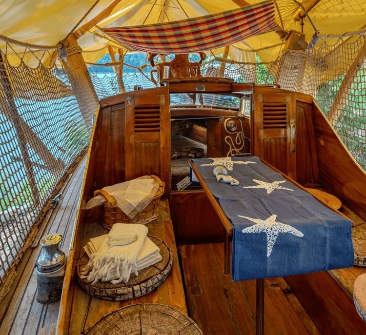 Sailboat cockpit with table, starfish table runner, towels and a hammock under a yellow awning