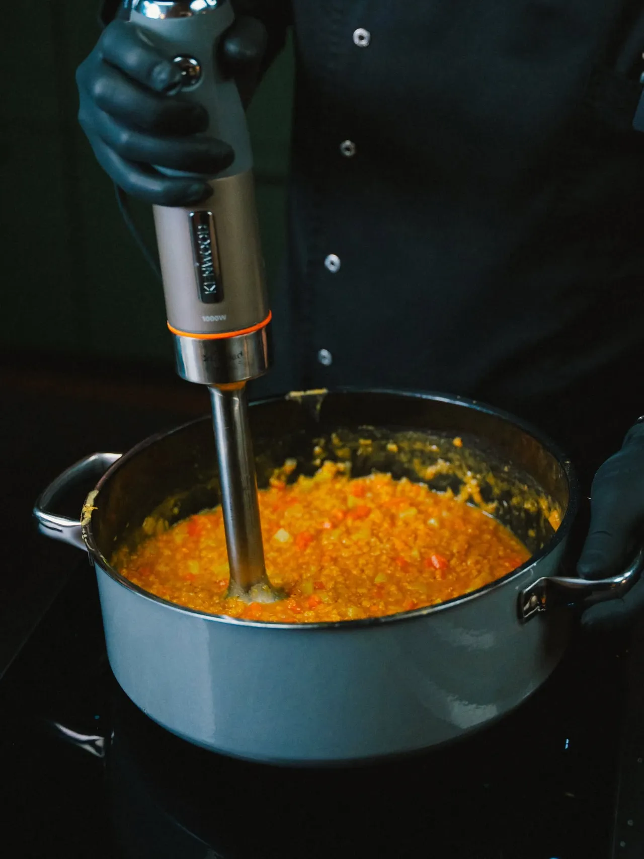 Sauce being blended with a hand blender