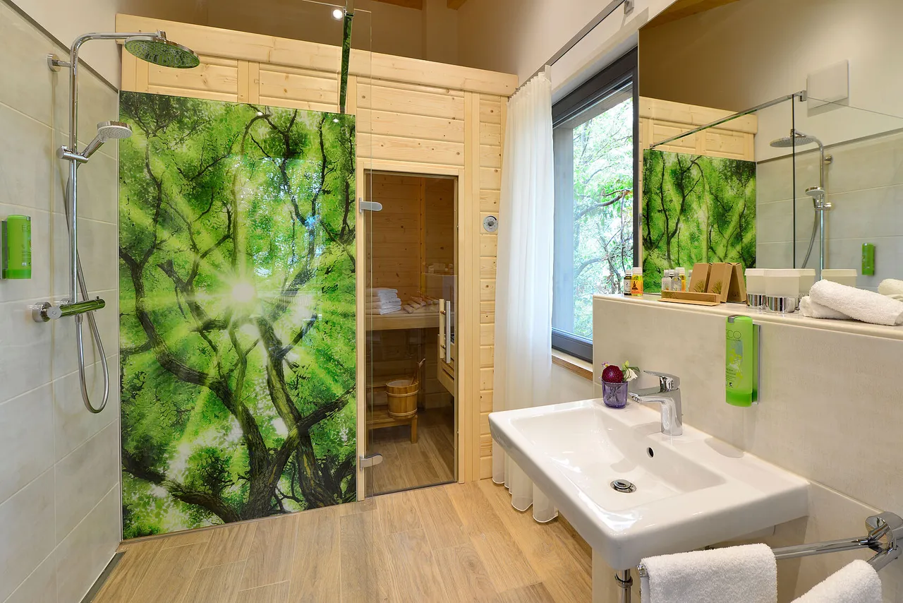 Modern tree chalet bathroom with rain shower, washbasin and private sauna
