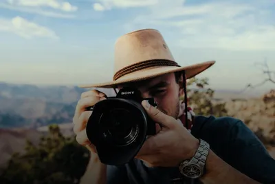 Photography course: man in a hat taking a photo with a camera