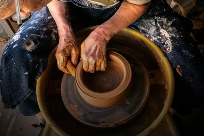 Workshop: hands shaping clay on a pottery wheel