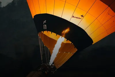 Hot air balloon ride: burner flame lighting up an orange balloon