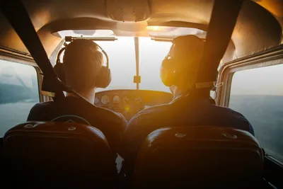 Sightseeing flight: two pilots with headsets in a small plane cockpit