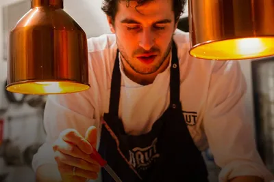 Gourmet moments: chef plating food under warm heat lamps