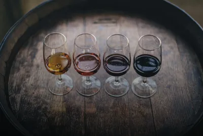 Wine tasting: four glasses of different wines on a wine barrel