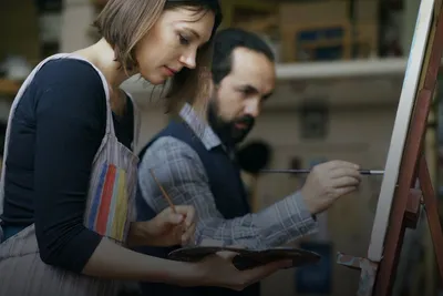 Paint your partner: woman and man painting together at an easel