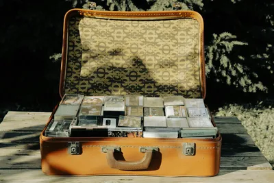 Open vintage suitcase packed with bundles of banknotes