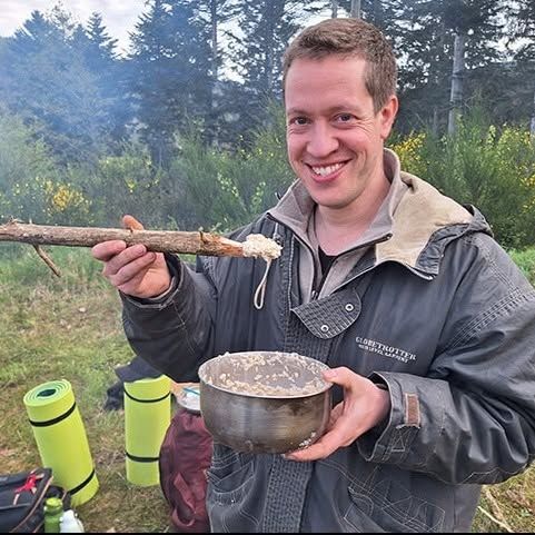 A person eating a simple meal in a camping environment