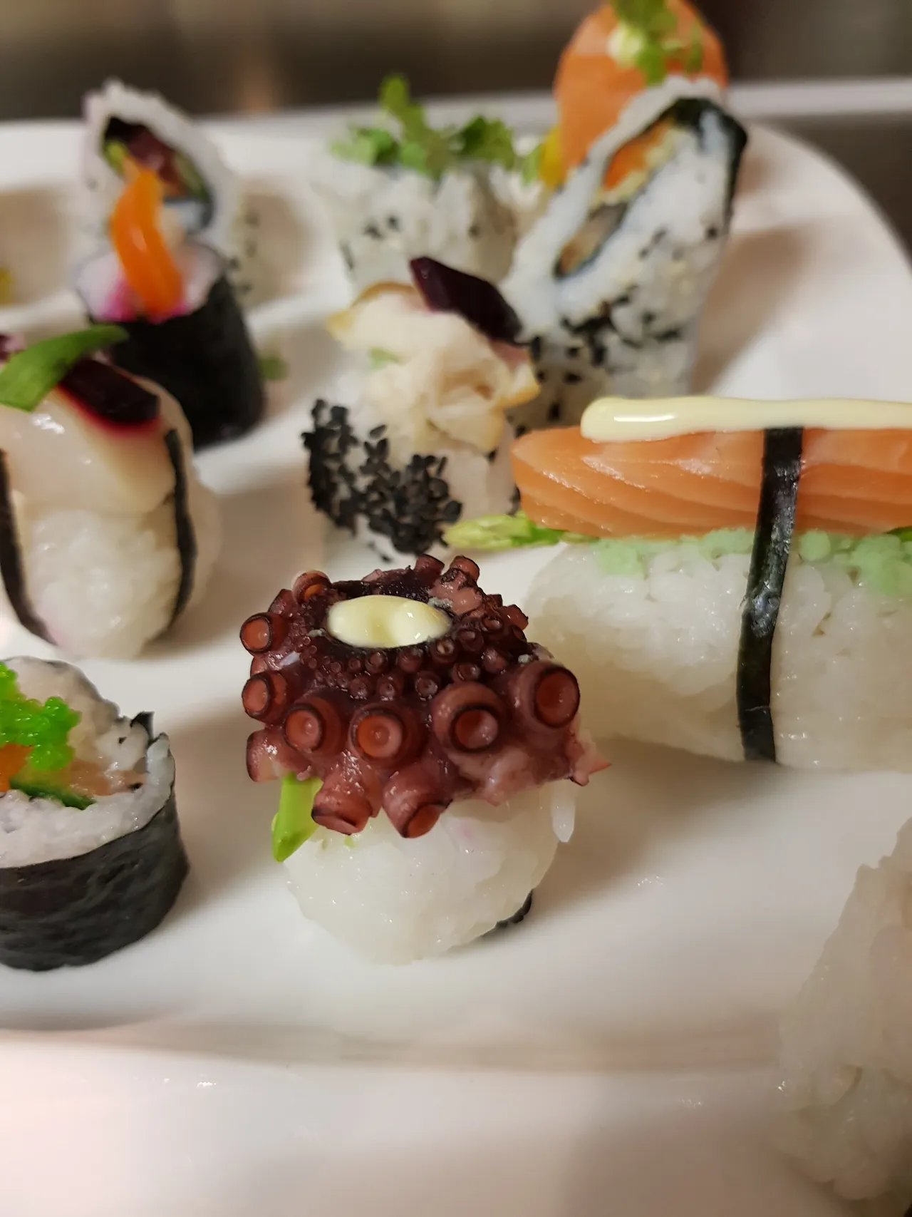 Variety of sushi rolls arranged on serving platters