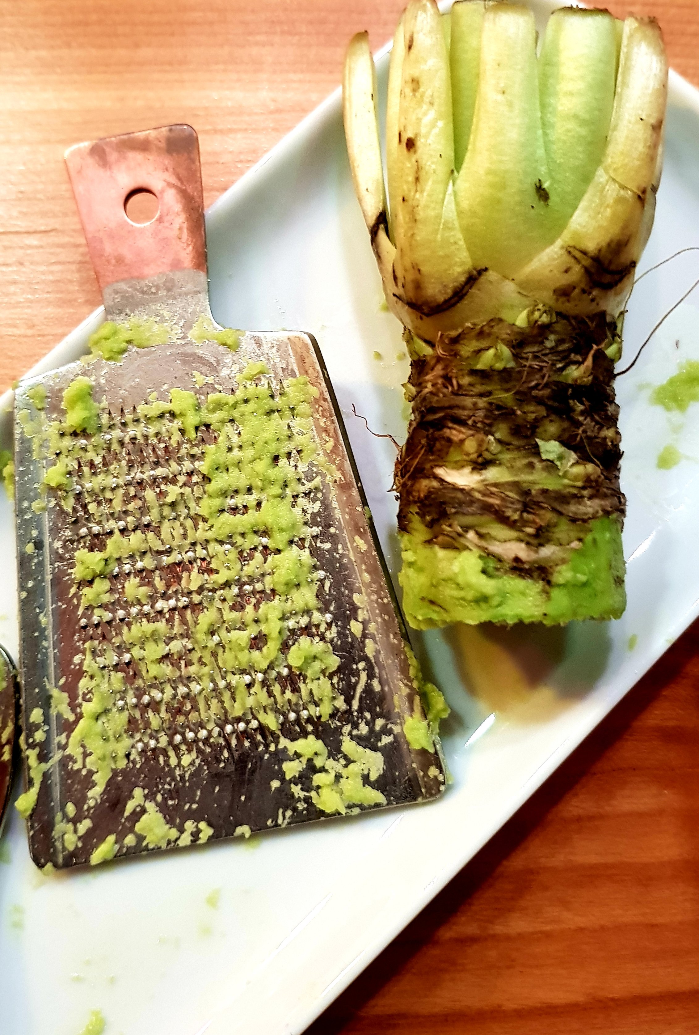 Fresh wasabi root and sushi ingredients on a table
