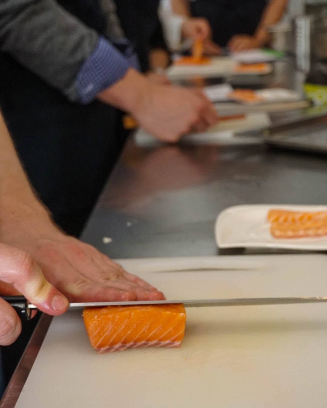 A person slicing a salmon filet