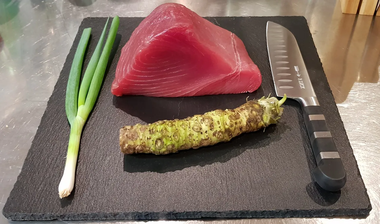 Tuna, fresh wasabi and spring onion on a dark plate