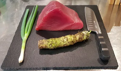 Tuna, fresh wasabi and spring onion on a dark plate