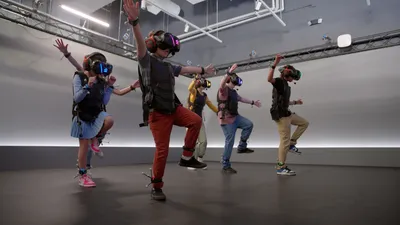 A group of people dancing while wearing VR glasses