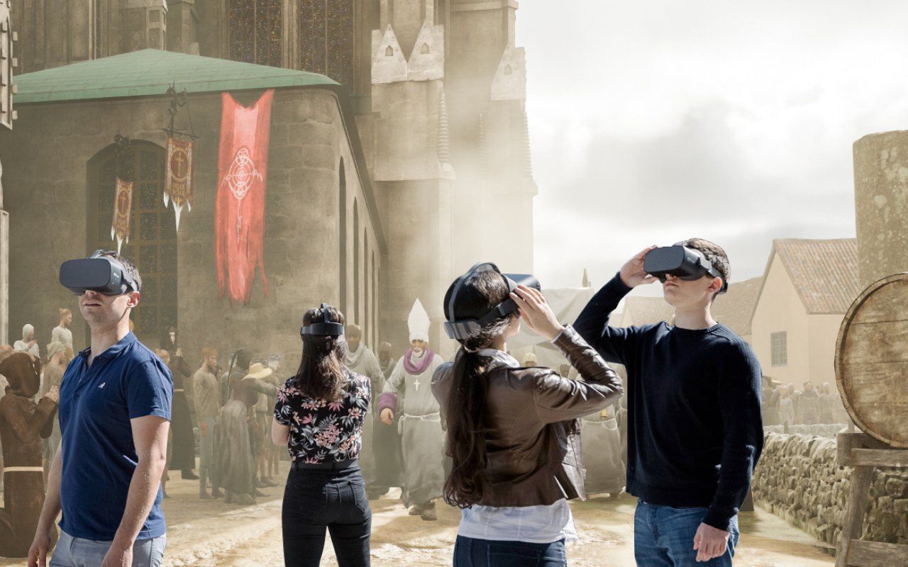 Group of visitors wearing VR headsets immersed in a medieval Vienna street scene with a monk procession