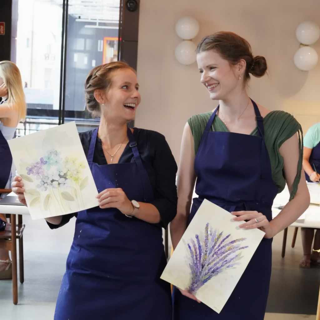 Two girls holding watercolour paintings