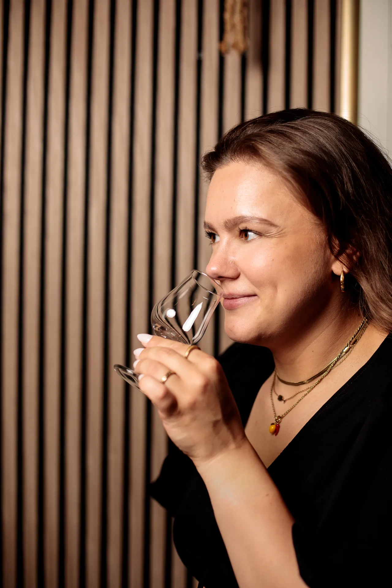 Close-up of a woman nosing a glass of whiskey during a tasting session.
