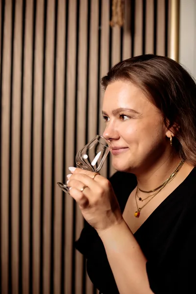 Close-up of a woman nosing a glass of whiskey during a tasting session.