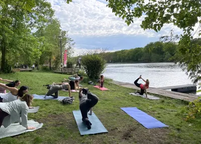 Outdoor yoga class on a riverside meadow by the Spree in Berlin